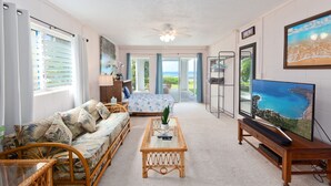 A spacious living room with a sofa, coffee table, and a television.