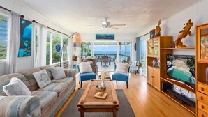 A spacious living room with a sofa, chairs, a coffee table, and a television.