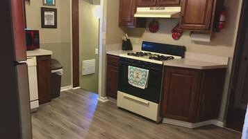A kitchen with wooden cabinets, a stove, and a microwave.