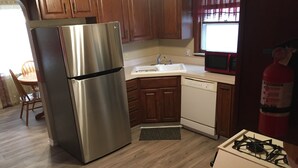 A kitchen with wooden cabinets, a stainless steel refrigerator, a microwave, a dishwasher, and a gas stove. - Cozy & Quiet beautiful 4 bedrooms , close to downtown, Cleve clinic  (Parma)