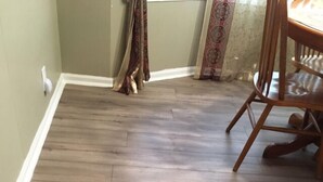 A room with a wooden floor, a dining table with chairs, and a patterned curtain. - Cozy & Quiet beautiful 4 bedrooms , close to downtown, Cleve clinic  (Parma)