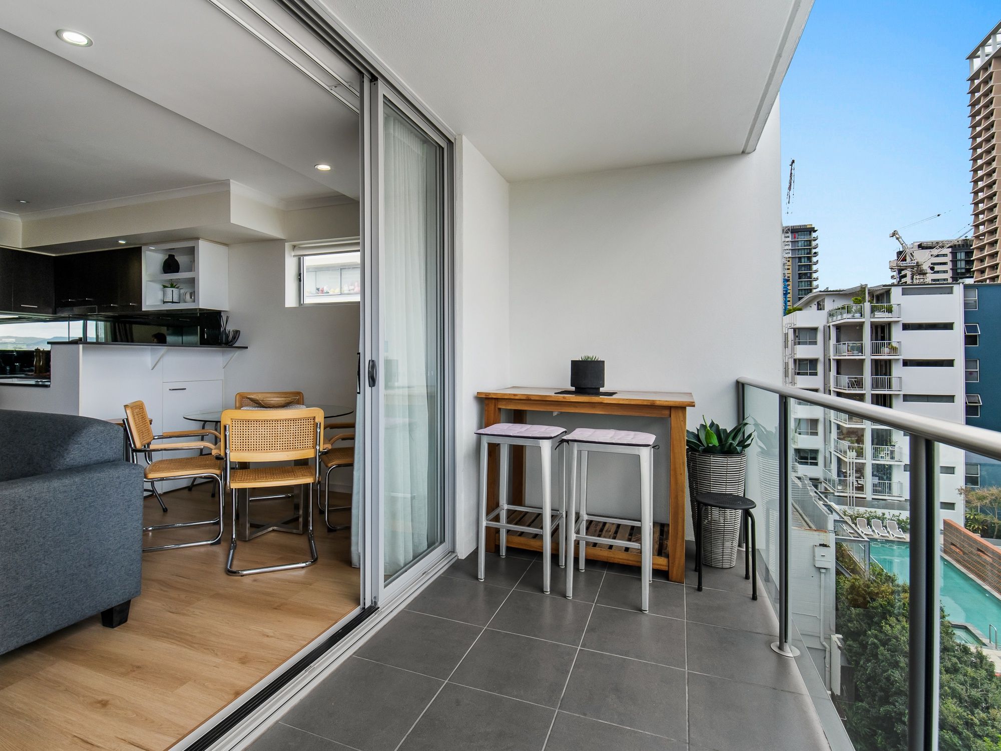 En moderne lejlighed med balkon, spiseplads og køkken.