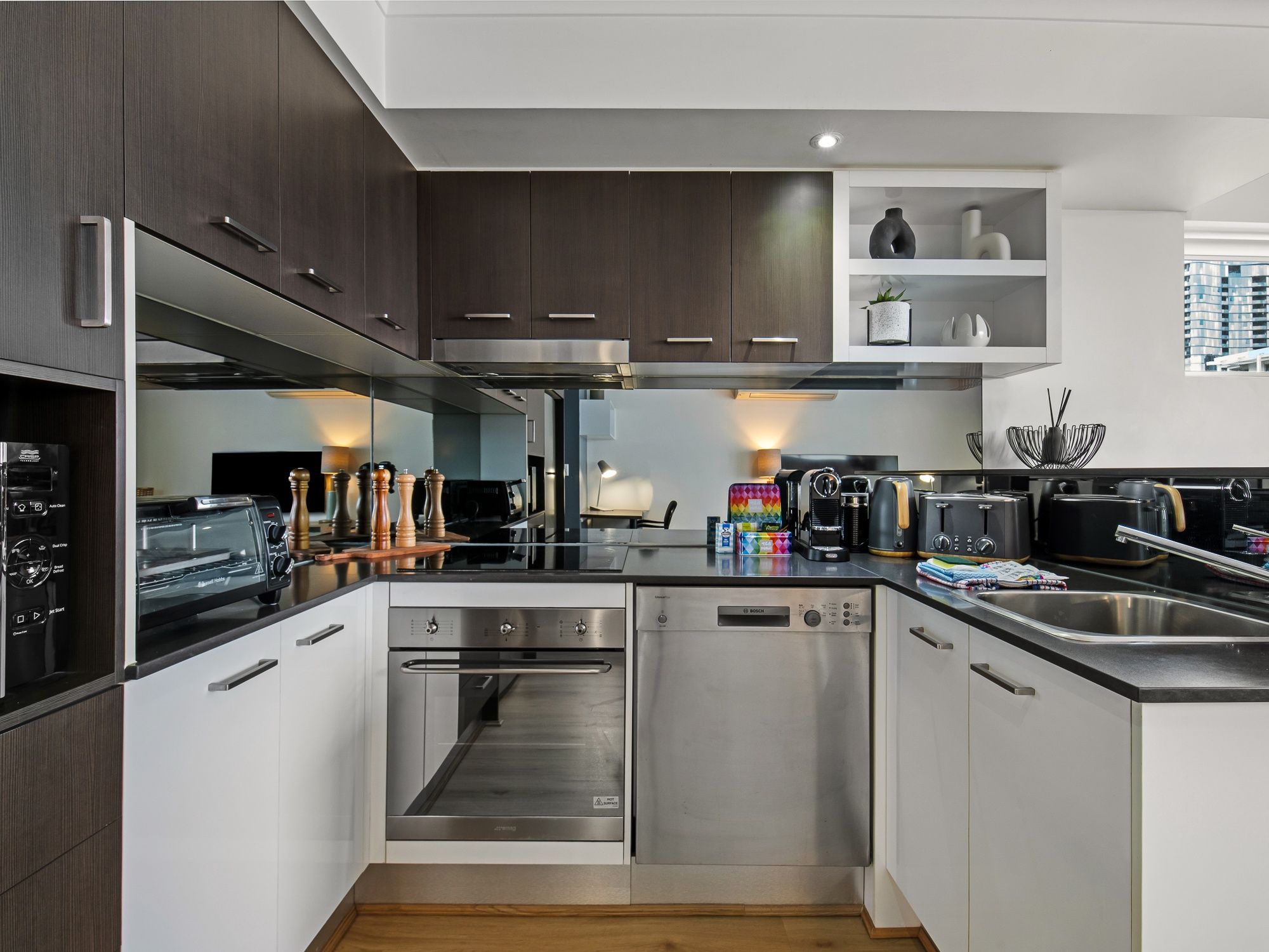 Una cocina moderna con electrodomésticos de acero inoxidable, armarios de madera y horno empotrado.