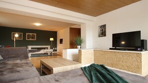 A modern living room with a sofa, a coffee table, a TV, and a plant. - Geräumige Wohnung in Altenau mit Terrasse (Altenau)