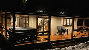 A modern house with a covered porch, a staircase leading to the upper floor, and a car parked outside. - Bear Creek Lodge (Dorchester)