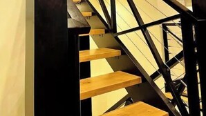 A modern staircase with black metal railings and wooden steps. - Bear Creek Lodge (Dorchester)