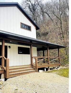 A two-story building with a porch and wooden railings.