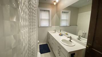 Tina con regadera, secadora de cabello, toallas, jabón