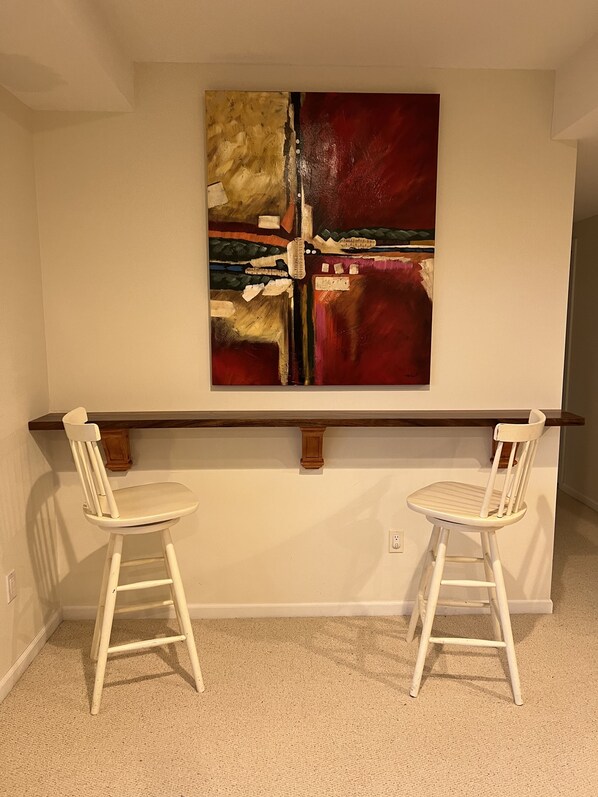 A room with a white wall, a red abstract painting, and two white chairs with wooden legs. - Family Luxury Resort Home (Sking/Golf) Treetops, Otsego, Shanty, Boyne (Gaylord)