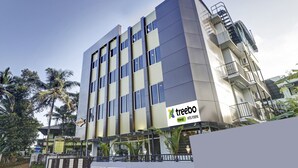 A modern hotel building with a sign for 'treebo trend HOTEL PUSHPAK'. - Treebo Pushpak 500 mtrs from Chottanikkara temple (Kanayannur)