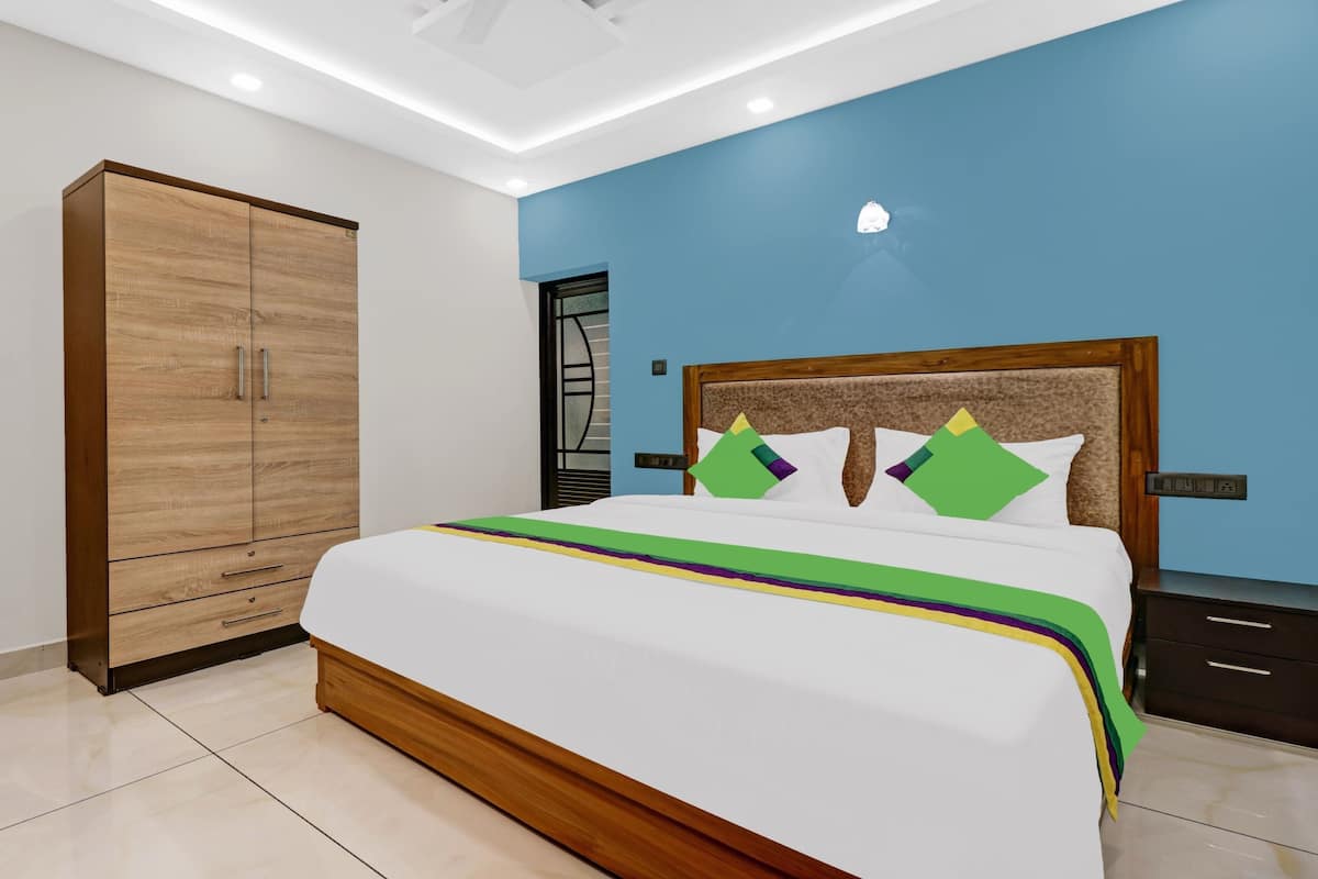 Un dormitorio con cama, armario y mesita de noche.
