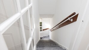 A staircase with a wooden handrail and carpeted steps leading to a landing. - JOIVY Beautiful 2-Br Mews Home, Near Princes Street (Edinburgh)