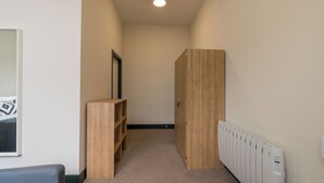 A narrow hallway with a wooden wardrobe, a radiator, and a framed picture on the wall. - JOIVY Meadows Park En-Suite Rooms (Edinburgh)