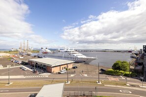 A large cruise ship docked at a port with a terminal building in the foreground. - JOIVY Fabulous 2Br Apartment W/Terrace & Bay View (Edinburgh)