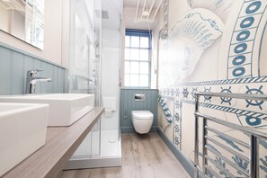 A bathroom with a shower, a toilet, and a sink.