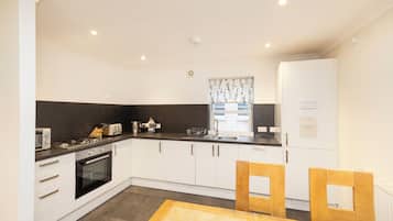 Apartamento, 3 quartos | Cozinha privada | Geladeira, micro-ondas, fogão, cooktop