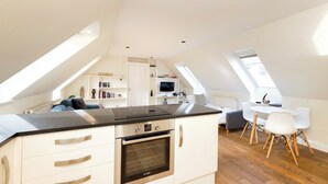 A modern loft apartment with a kitchen, dining area, and a cozy living space. - JOIVY Inviting Flat Near Edinburgh Castle W/ Parking (Edinburgh)