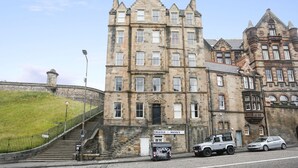 A historic stone building with multiple windows and a prominent entrance.