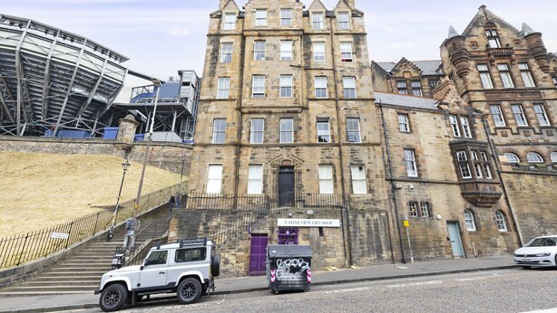 A historic building with a prominent entrance, a gift shop, and a modern structure nearby. - JOIVY Charming 2-Bed Flat Near Edinburgh Castle (Edinburgh)