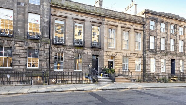 A row of traditional stone buildings with multiple windows and a black iron fence. - JOIVY 3BR Flat in Haymarket with Free Parking (Edinburgh)