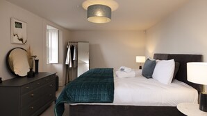 Une chambre à coucher avec un lit, une commode et un miroir.