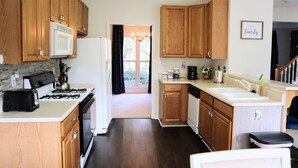 A kitchen with wooden cabinets, a microwave, stove, and a sink. - Spacious, Relaxed 5 Bedroom Getaway (LILBURN)