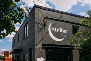 A building with a sign for 'Stellar Suites' featuring a crescent moon logo. - Market #10 · Stellar Suites | Queen of Nulu | Boutique Hotel (Louisville)