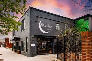 A building with a sign reading "Stellar Suites" and a storefront with glass doors.