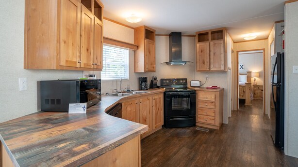 A compact kitchen with wooden cabinets, a built-in oven, and a refrigerator.