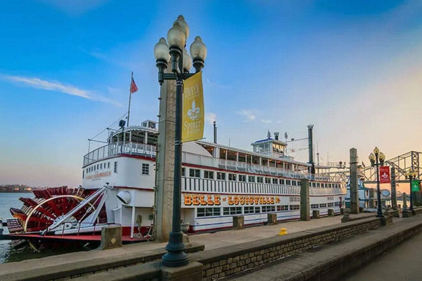 Un barco de gran tamaño atracado en un muelle, con un letrero visible que dice 'Belle of Louisville'.