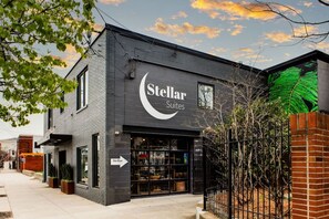 Ein Gebäude mit einem Schild, auf dem "Stellar Suites" steht, und einer sichtbaren Schaufensterfront mit Glastüren.