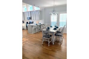 Enjoy meals in the kitchen with a central island and dining area featuring a table and chairs.