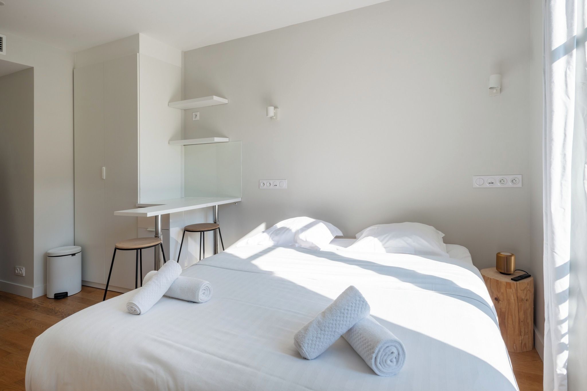 Ein modernes Hotelzimmer mit einem Bett, einem Schreibtisch und einem Stuhl.
