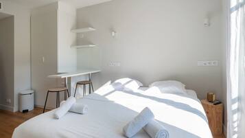 Ein modernes Hotelzimmer mit einem Bett, einem Schreibtisch und einem Stuhl.