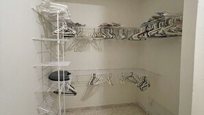 Un armario con varios estantes y espacio para colgar ropa.