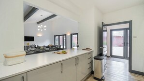 Una cocina moderna con una isla grande, horno empotrado y un cesto de basura.