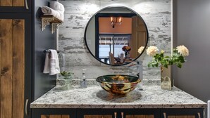 A bathroom with a wooden vanity, a large mirror, a glass bowl sink, and a vase with flowers. - Serene Lakefront Cottage Escape (Rivière-Rouge)