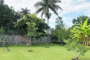 Relax amidst lush greenery and vibrant tropical plants in this serene outdoor space.