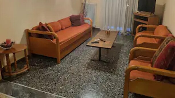 A living room with a sofa, armchairs, a coffee table, and a television. - Lovely 1-bed Apartment in Athina (Athens)