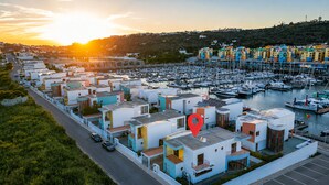 A marina with colorful buildings, a parking lot, and a road.