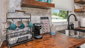 Eine Küche mit einer Kaffeestation, einschließlich Tassen, einer Kaffeemaschine und einem Schild mit der Aufschrift 'I love coffee'.