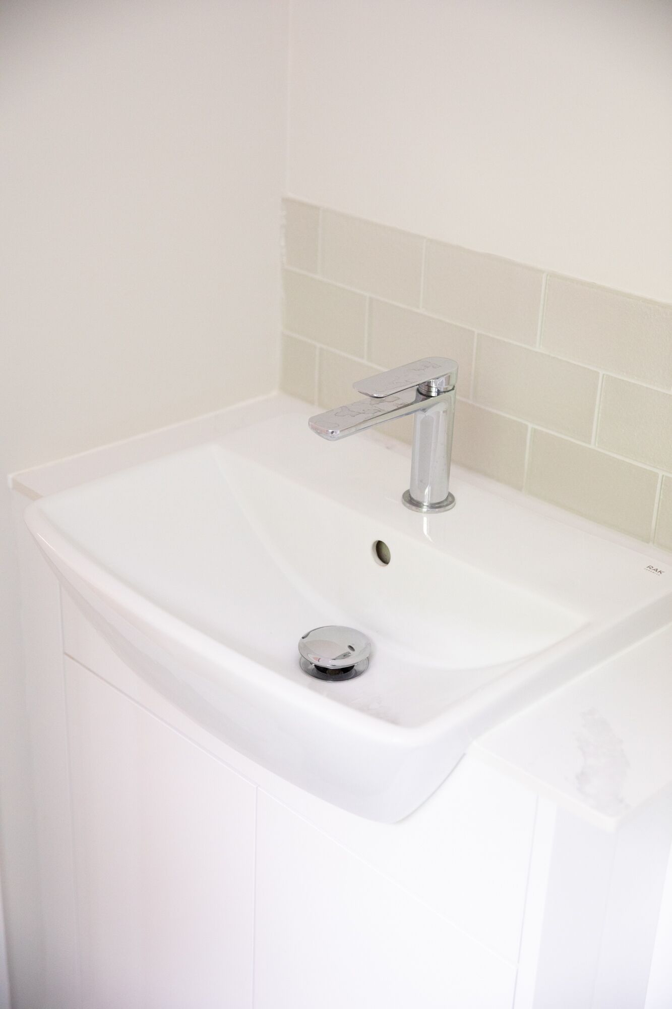 Un lavabo de salle de bain blanc, doté d’un robinet moderne et d’un bouchon d’évier.