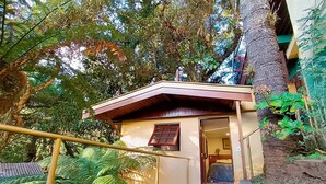A small, single-story building with a sloped roof, a door, and a window. - Suíte Privativa em Jardim1km do Capivari (Campos do Jordão)