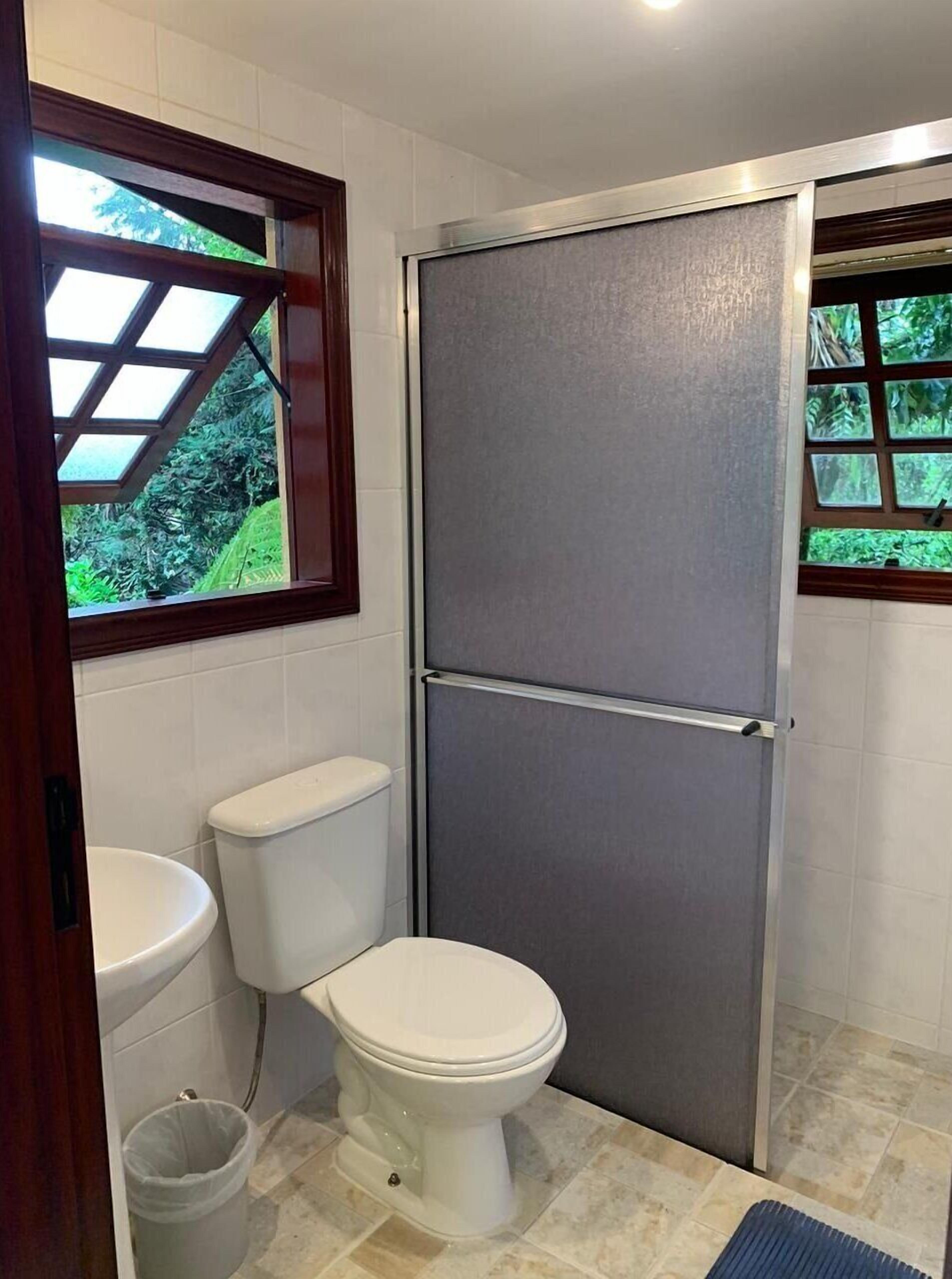 Une petite salle de bain comprenant des toilettes, un lavabo et une cabine de douche.
