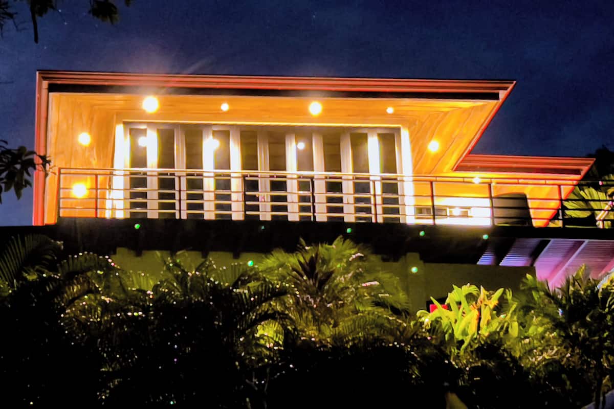 Um edifício moderno com design arquitetônico único, apresentando uma estrutura saliente em balanço e uma série de janelas iluminadas.