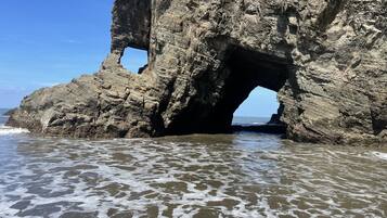 Formación rocosa natural con un arco grande sobre el agua.