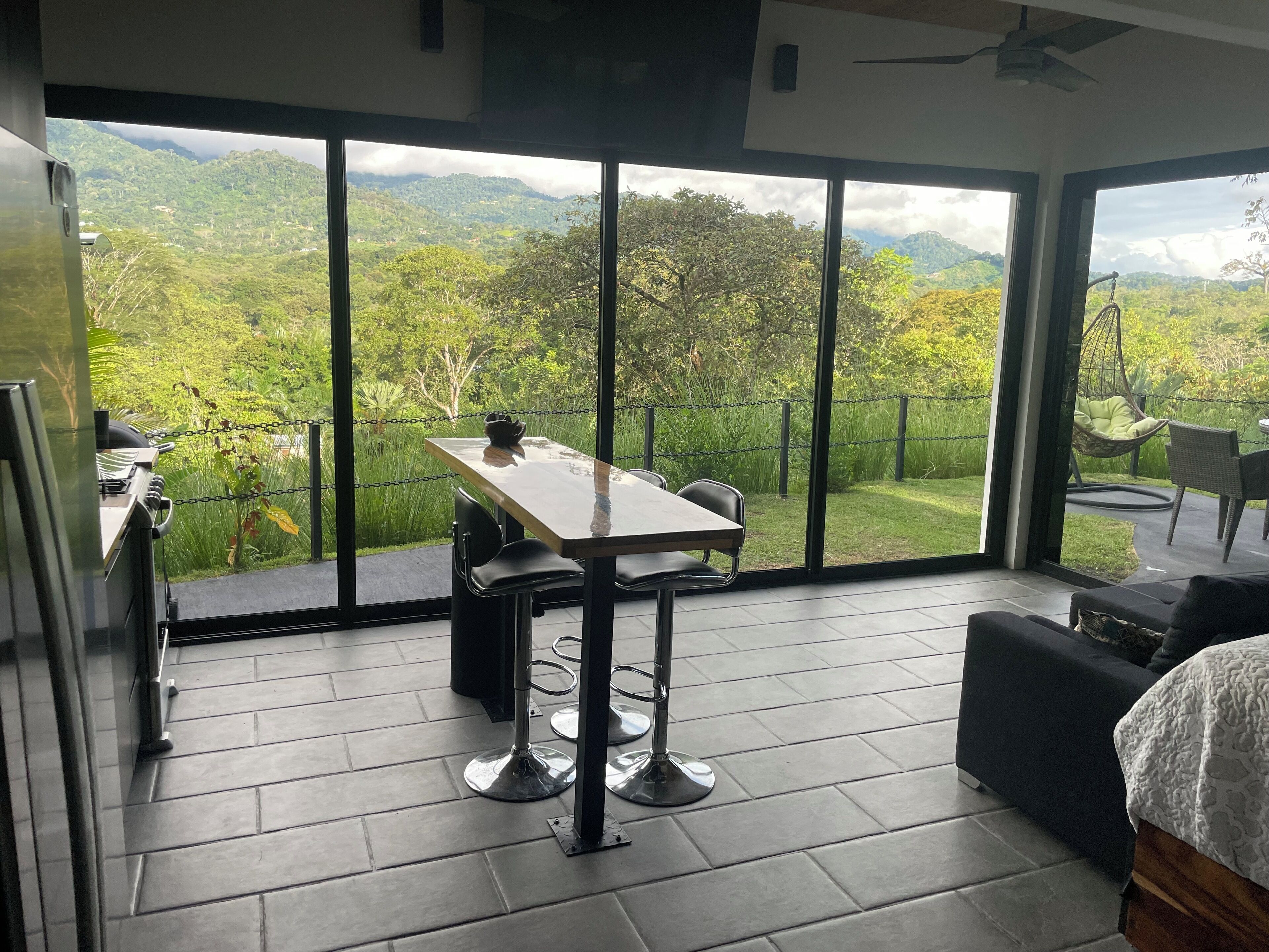 Une chambre moderne dotée d’une grande porte-fenêtre coulissante donnant sur un balcon offrant une vue panoramique sur les montagnes.