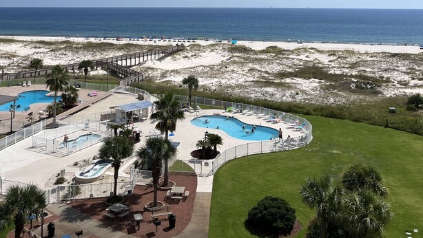 Un resort con varias piscinas, una playa y vista al océano.