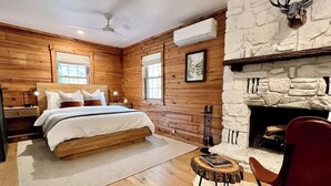 Une chambre confortable avec un lit en bois, une cheminée et un fauteuil rouge.