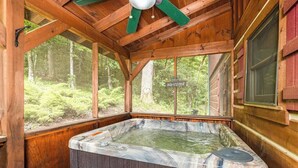 A hot tub in a wooden cabin with a 'Welcome' sign, surrounded by forest views. - Pigeon Forge Cabin /Game Room/Dog Friendly/Hot Tub (Pigeon Forge)